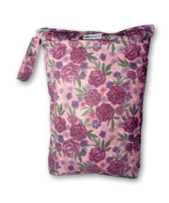 en stor påse med ljusrosa bakgrund och mörka lila blommor som print. påsen har en stor öppningsbar ögla på ena sidan och en dragkedja på toppen.